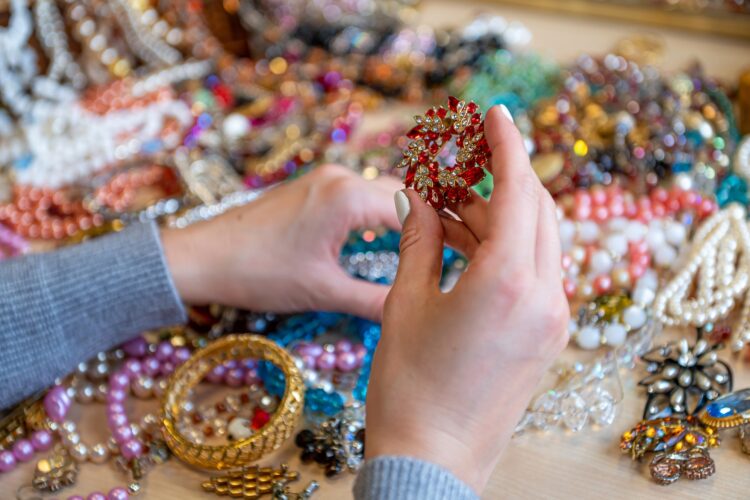 female hands holding a pile of jewelry, closeup