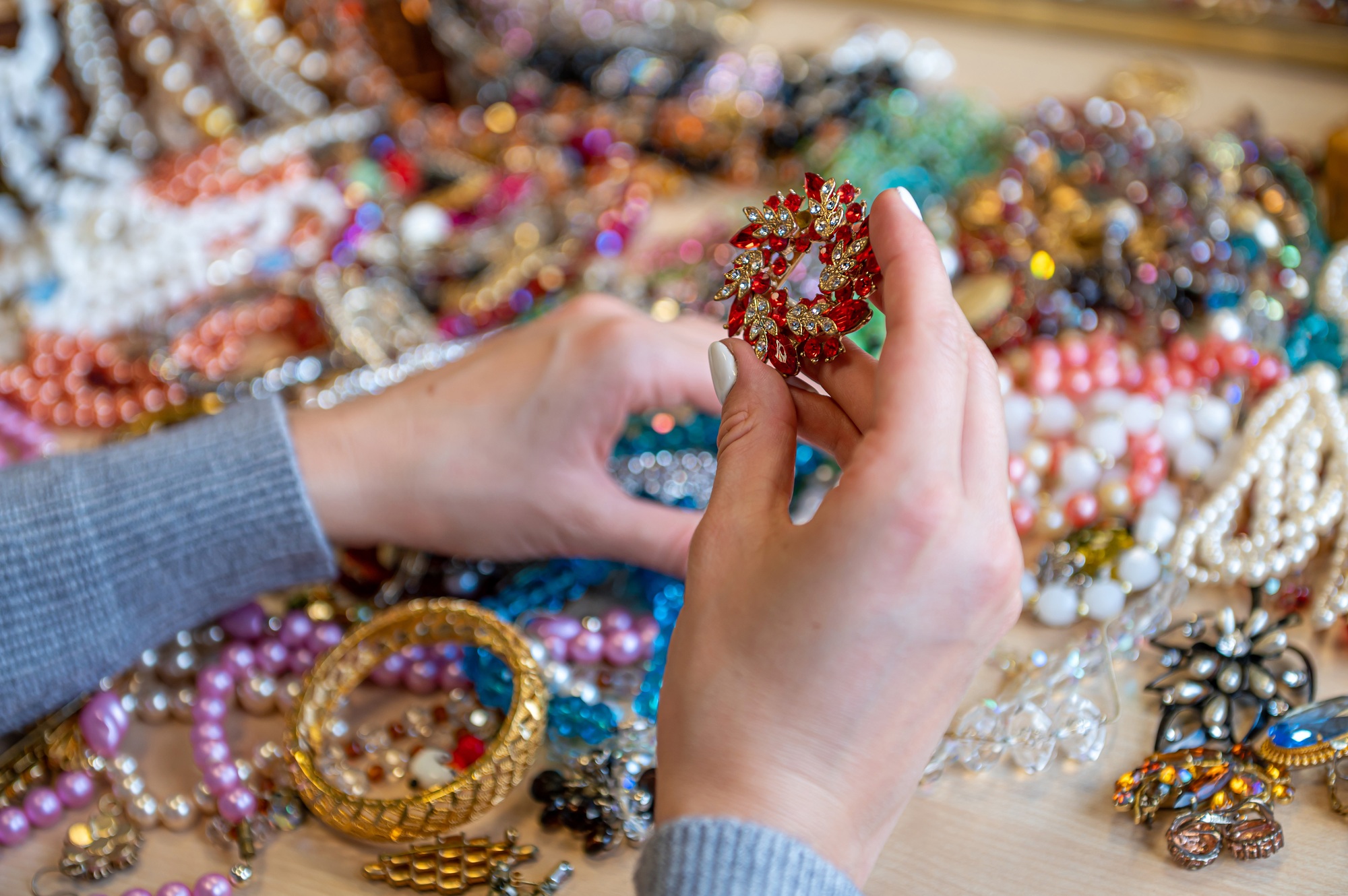 female hands holding a pile of jewelry, closeup