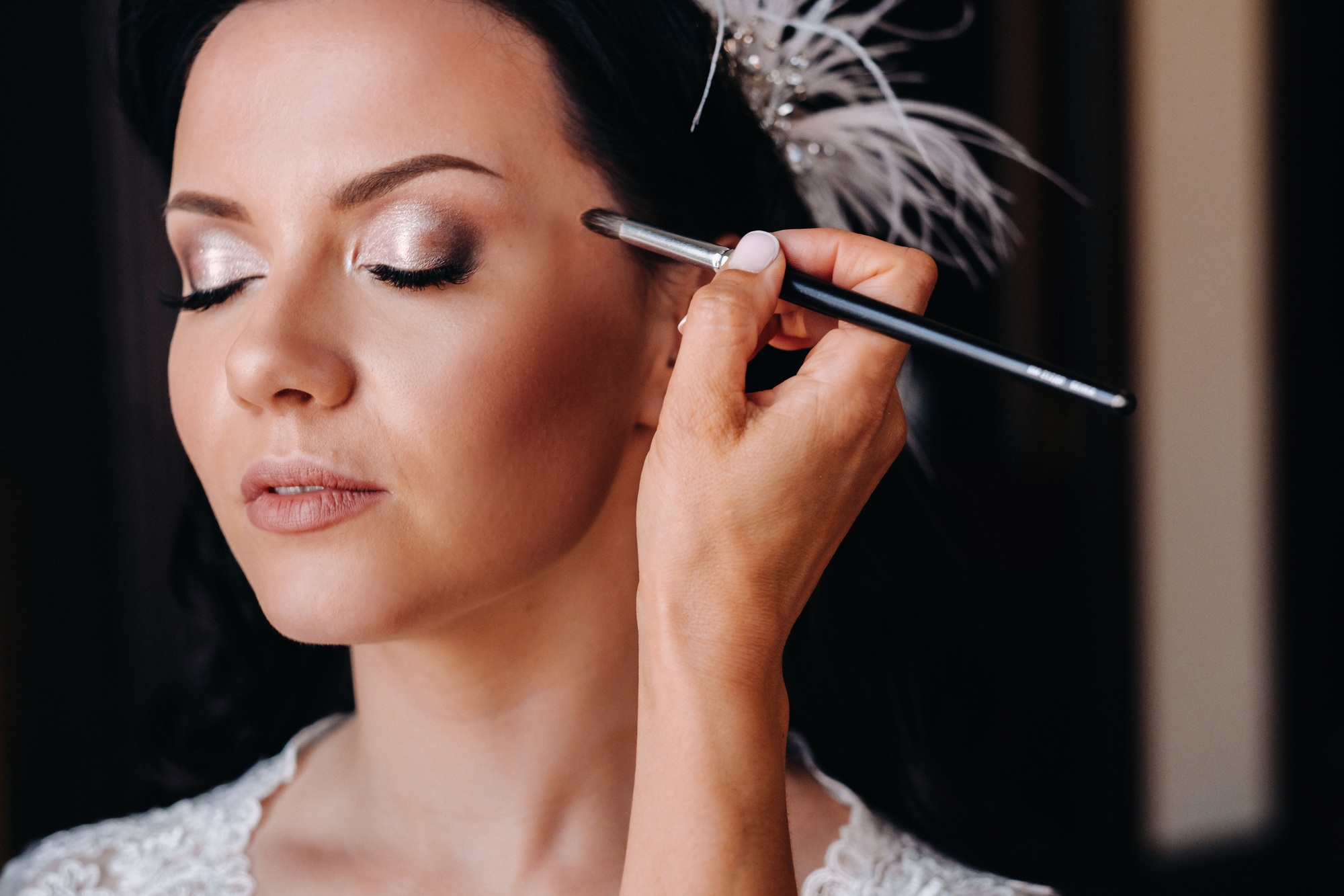 The makeup artist does the bride's makeup.Morning of the bride