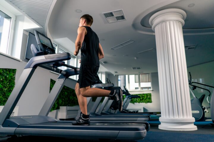 young athlete runs on a treadmill in the gym during cardio training process of losing weight