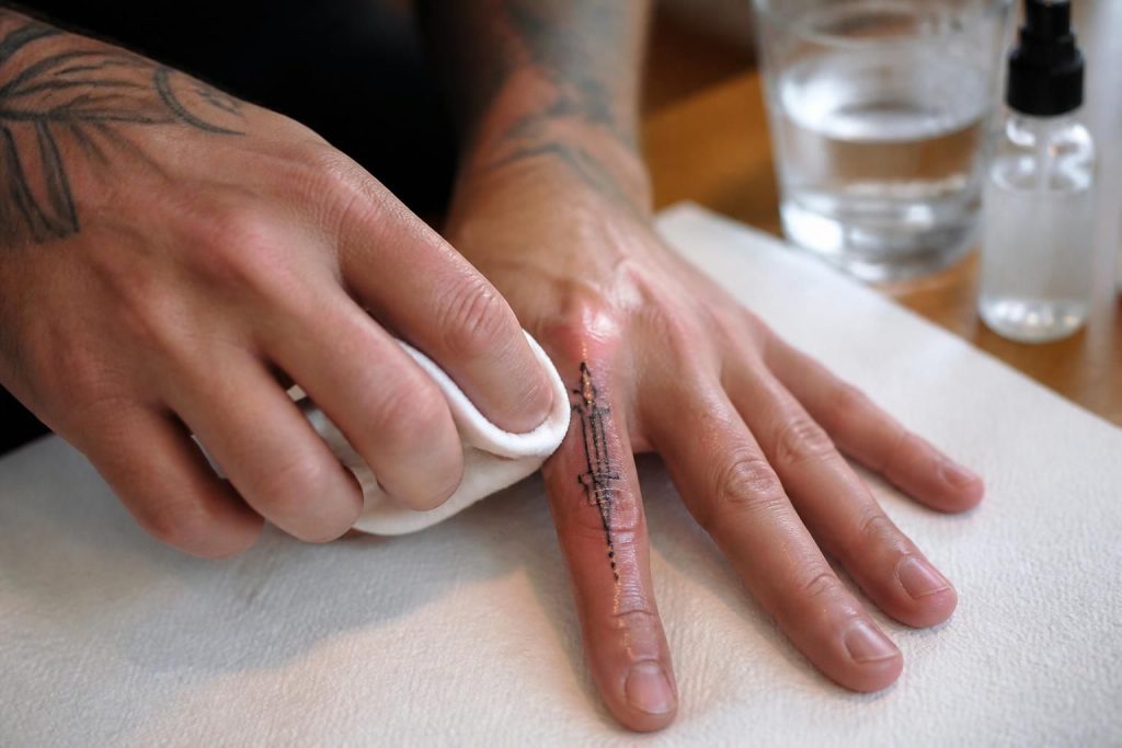 découvrez nos conseils essentiels pour bien prendre soin de votre tatouage doigt homme après la séance, afin d'assurer une cicatrisation rapide et un rendu optimal.